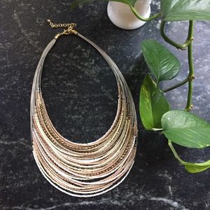 Bead necklace with gold tones, taupe and white.